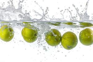 A group of green olives falling into water photo