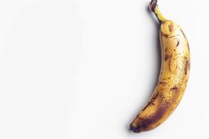 A banana is shown on a white surface photo