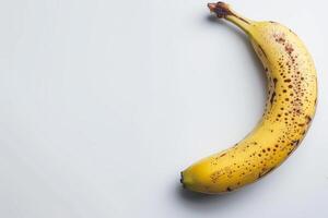 A banana with spots on it is on a white background photo