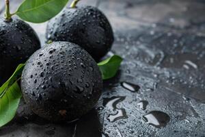 Three black avocados with water drops on a dark background photo