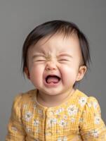 A baby is crying and making a funny face photo