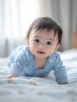 A baby in blue pajamas laying on a bed photo
