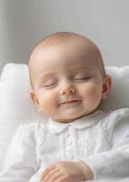 A baby is sleeping in a white outfit photo