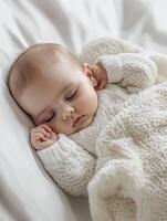 A baby sleeping in a white sweater photo