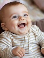 A baby is smiling while sitting on a bed photo