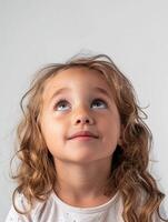 A little girl with curly hair looking up photo