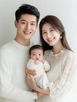 A young couple and their baby are posing for a photo