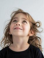 A young girl is looking up with her hair blowing in the wind photo