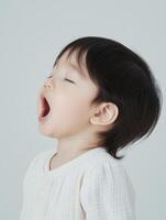 A baby girl with her mouth open and her eyes closed photo