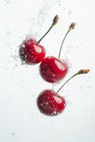 Three cherries are floating in water with bubbles photo
