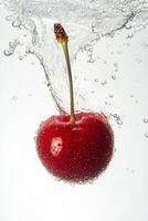 A cherry is being splashed in water photo