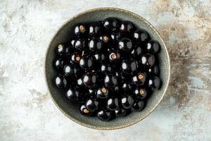 Black currant in a bowl on a white background photo