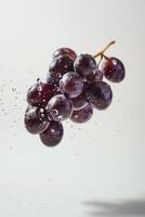 A bunch of grapes is being sprayed with water photo