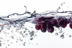 A bunch of grapes is being splashed into the water photo