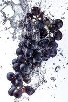 A bunch of grapes being splashed with water photo