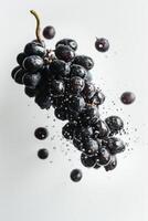 A bunch of grapes is being splashed with water photo