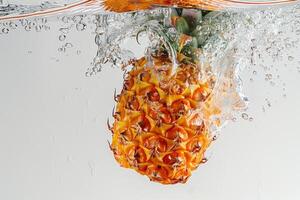 A pineapple is being splashed into the water photo