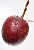 A red fruit with water droplets on it photo