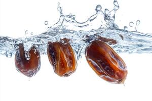 Dates falling into water on a white background photo