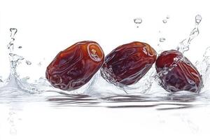 Three dates falling into water on a white background photo