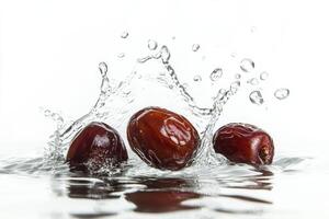 Three dates falling into water on a white background photo