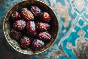 A bowl of dates on a blue and white table photo