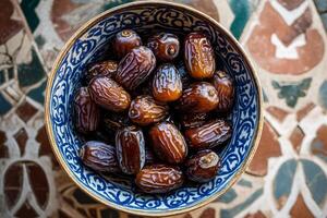 Dates in a bowl on a tiled floor photo