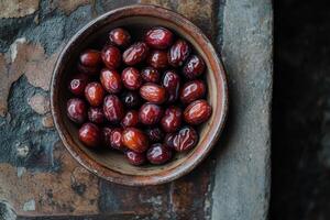 A bowl full of dates on a wooden table photo