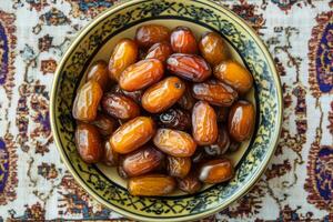 A bowl of dates on an oriental rug photo