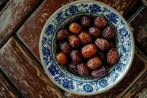 A bowl of dates on a wooden table photo