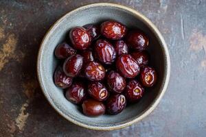 A bowl of dates on a table photo
