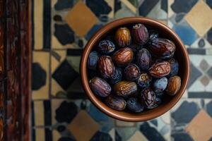 A bowl of dates on a tiled floor photo