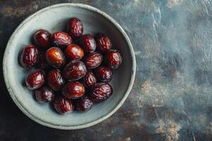 A bowl of dates on a table photo