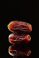 Two dates on a black surface photo