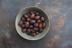 Dates in a bowl on a dark background photo