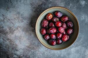 A bowl of ripe plums on a gray background photo