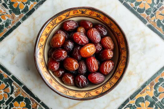 A bowl of dates on a marble table photo