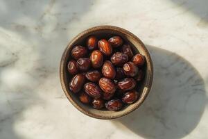 A bowl of dates on a marble counter photo