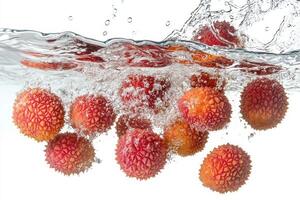 Fresh lychee fruit falling into water photo