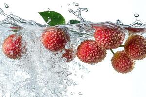 Fresh lychee fruit falling into water photo