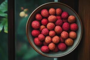 A bowl filled with red and green litchis photo