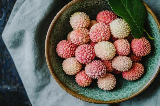 A bowl of lychees with a leaf on top photo