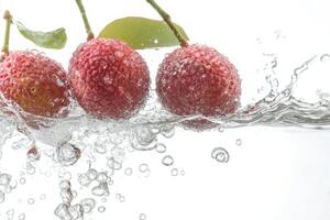 Three litchis are splashing in water photo