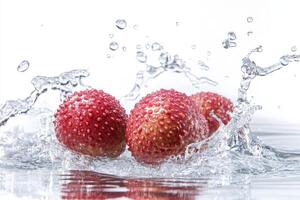 Three strawberries are splashing into the water photo