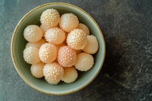 A bowl filled with white balls of fruit photo