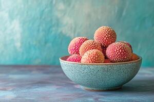 A bowl of lychees on a blue background photo