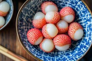 A bowl of strawberries with chopsticks in it photo
