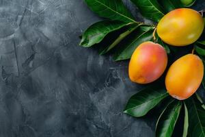 Mango fruit on a dark background with leaves photo