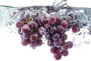 A bunch of grapes is being submerged in water photo
