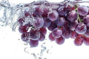 A bunch of grapes is being splashed into the water photo